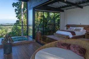 a bedroom with two beds and a large glass window at El Edén Country hotel y Club Residencial in Circasia +154 photos