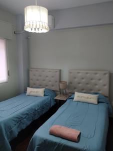 a room with two beds with blue sheets at Departamento céntrico muñecas in San Miguel de Tucumán