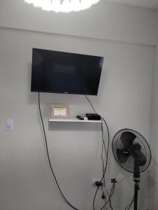 a flat screen tv on a wall with a fan at Departamento céntrico muñecas in San Miguel de Tucumán