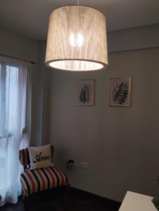 a chandelier hanging over a chair in a room at Departamento céntrico muñecas in San Miguel de Tucumán +3 photos
