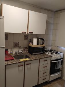 a kitchen with a sink and a stove at Departamento céntrico muñecas in San Miguel de Tucumán