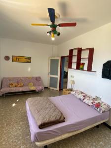 a bedroom with a bed and a ceiling fan at Beach house in Izâmmoûrâne