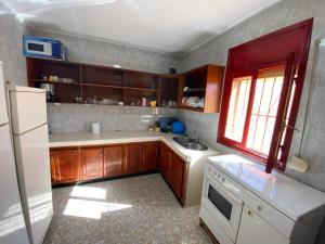 a kitchen with wooden cabinets and a white refrigerator at Beach house in Izâmmoûrâne