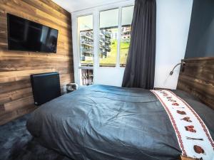 sypialnia z łóżkiem i telewizorem z płaskim ekranem w obiekcie Résidence Rond Point Des Pistes B - Appartement rénové·Départ et retour ski aux pieds· MAE-2414 w mieście Tignes