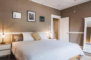 ein Schlafzimmer mit einem großen weißen Bett und zwei Lampen in der Unterkunft Historic Victorian Home on UT near to Dtwn in Austin