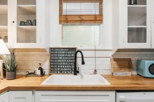 eine Küchentheke mit einer weißen Spüle und einer Arbeitsplatte in der Unterkunft Historic Victorian Home on UT near to Dtwn in Austin + 39 Fotos