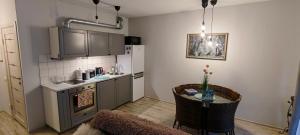a kitchen with a table and a kitchen with a stove at Ozas Park Apartments in Vilnius