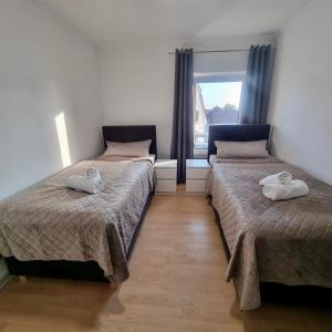 two beds in a room with a window at Ferienwohnung Fleiger 4 in Achim Zentrum in Achim +4 photos