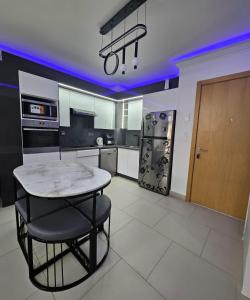 a kitchen with a table and a kitchen with purple lights at Marassi luxury 2 bedroom in El Alamein +2 photos