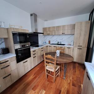 a kitchen with a wooden table and a wooden floor at StGosweet in Saint-Gaudens +3 photos