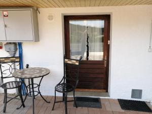 a table and chairs in front of a door at Le Logis du Chalet Perce-Neige in Châtel-Saint-Denis