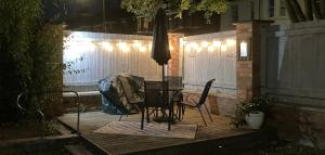a table and chairs on a wooden deck at night at 65A Beauchamp in Leamington Spa