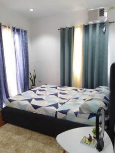 a bedroom with a bed with blue curtains and a table at Duplex House for Rent with 3 Bedrooms good for 6 in Minglanilla