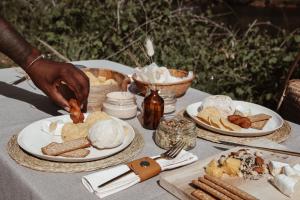 a table with plates of food on it at Stanley Island in Plettenberg Bay