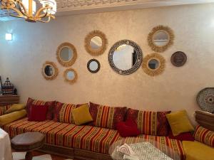 a living room with a couch and mirrors on the wall at Riad SARSAR airport in Marrakesh