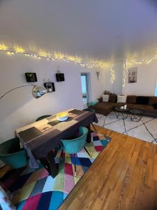 una sala de estar con una mesa y un sofá en Spacieux Appartement Persan, en Persan