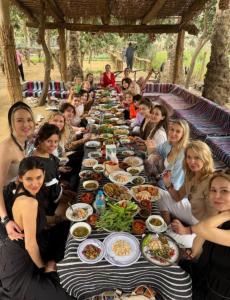 a group of people sitting around a long table of food at Revesta dahshur in Minshāt Dahshūr +93 photos