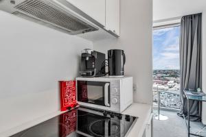 eine Küche mit einer Mikrowelle auf einer Theke neben einem Fenster in der Unterkunft 2-Bed Studio At The Heart of Birmingham City Center in Birmingham