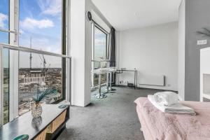 ein weißes Zimmer mit einem Bett und einem großen Fenster in der Unterkunft 2-Bed Studio At The Heart of Birmingham City Center in Birmingham