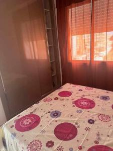 a bed with a flowered sheet on it with a window at DIAR Soufa in Chott Meriem +7 photos
