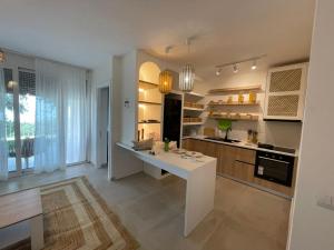a kitchen with a white island in a room at Appartamento Drymadhes in Gjilek