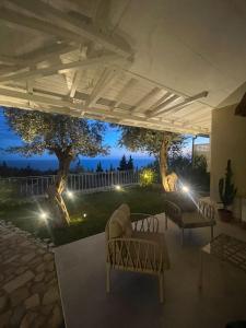 a patio with two chairs and a table with lights at Appartamento Drymadhes in Gjilek