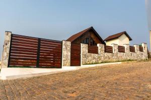 a wooden fence in front of a house at Recanto AlceNegro in Miguel Pereira