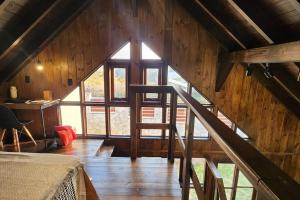 a room with a staircase in a wooden house at Recanto AlceNegro in Miguel Pereira