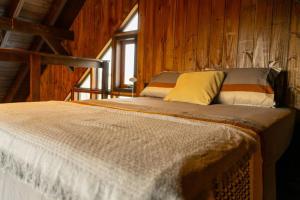 a bedroom with a bed in a wooden room at Recanto AlceNegro in Miguel Pereira