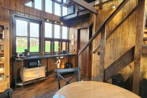 a room with a wooden wall with a table and a window at Recanto AlceNegro in Miguel Pereira