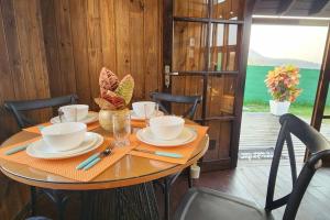 a table with plates and cups on top of it at Recanto AlceNegro in Miguel Pereira