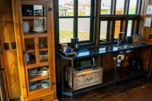 a kitchen with a counter with a window and a table at Recanto AlceNegro in Miguel Pereira