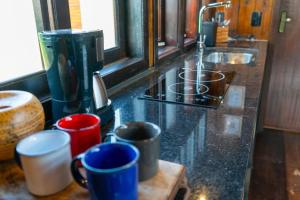 a kitchen counter with coffee cups and a sink at Recanto AlceNegro in Miguel Pereira