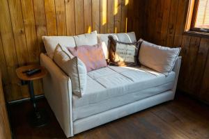 a couch with pillows on it in a room at Recanto AlceNegro in Miguel Pereira