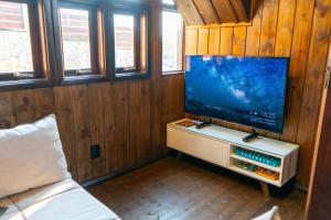 a living room with a flat screen tv and a couch at Recanto AlceNegro in Miguel Pereira