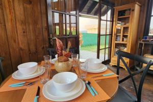 a wooden table with plates and cups on it at Recanto AlceNegro in Miguel Pereira