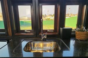 a sink in a bathroom with two windows at Recanto AlceNegro in Miguel Pereira