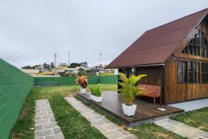 a wooden house with a bench and plants in a yard at Recanto AlceNegro in Miguel Pereira
