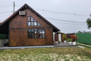 a large wooden house with a large window at Recanto AlceNegro in Miguel Pereira