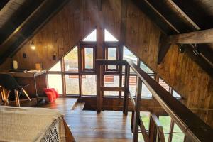 a room with a staircase in a wooden building at Recanto AlceNegro in Miguel Pereira