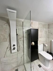 a bathroom with a shower and a toilet at Emerald Luxury Apartments - ATH Airport in Spata +33 photos