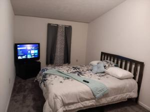 Un dormitorio con una cama y un televisor de pantalla plana. en A home away from Home, Near Fort Leonard Wood, en Waynesville