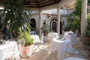 a patio with white tables and chairs and plants at Bed and breakfast Porto del Mar in Medulin