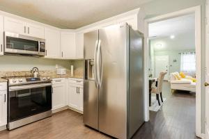 a kitchen with a stainless steel refrigerator and a table at Cozy home with BBQ grill, Firepit, Basketball and Foosball in Alpharetta