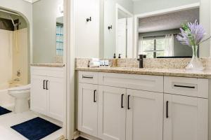 a white bathroom with a sink and a toilet at Cozy home with BBQ grill, Firepit, Basketball and Foosball in Alpharetta +48 photos