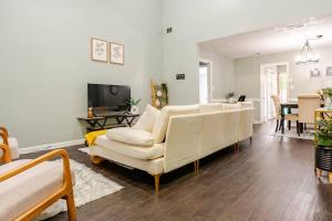 a living room with a white couch and a table at Cozy home with BBQ grill, Firepit, Basketball and Foosball in Alpharetta