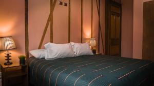 a bedroom with a bed with two pillows and two lamps at Hotel Reina Victoria Valparaíso in Valparaíso