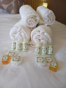 a pile of towels on a bed with bottles of soap at Inni Bush Guesthouse in Noordheuwel +98 photos