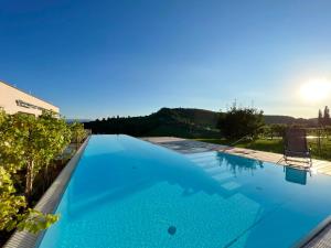a large blue swimming pool with a view at An der Lage - Exklusives Apartment mit Toskana Flair in Obegg