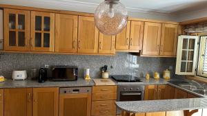 a kitchen with wooden cabinets and a counter top at Appartement tout confort Valpaços 2 in Valpaços